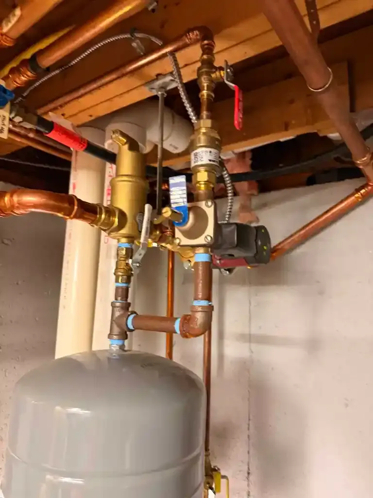 Close-up of residential plumbing pipes and valves in basement.