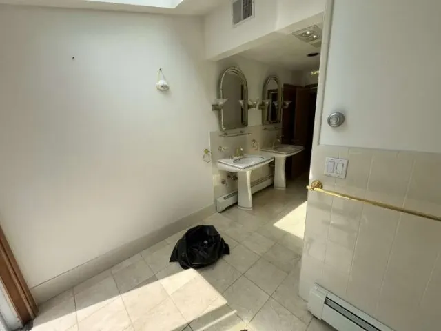 Outdated Newton MA bathroom with worn vanity, dated tile, and dim lighting before Sun Shore remodel