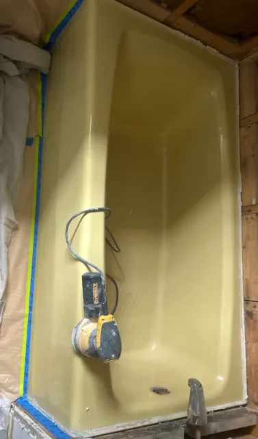 Worn yellow bathtub before reglazing