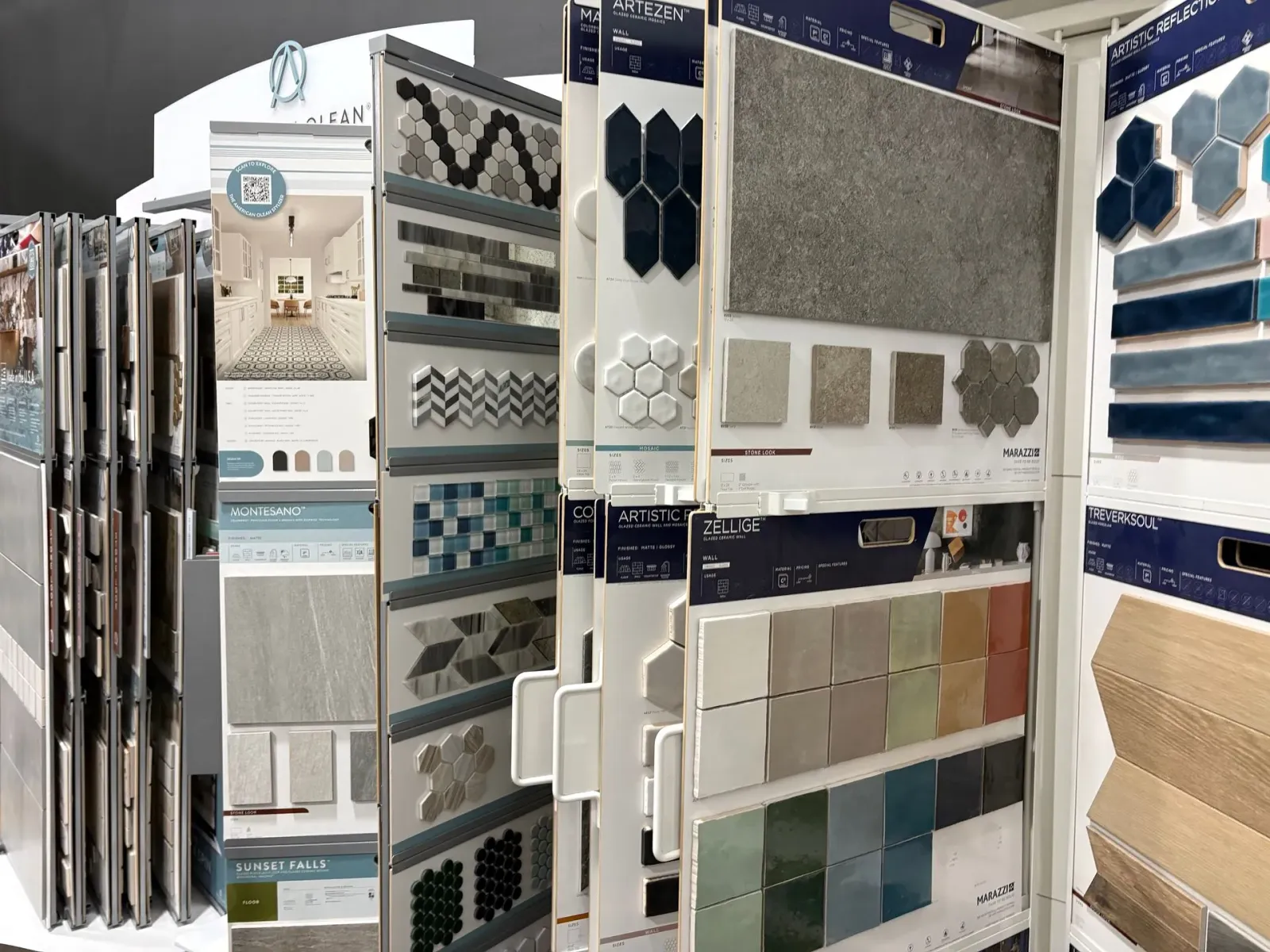 Tile display racks with assorted mosaic and stone samples in a showroom