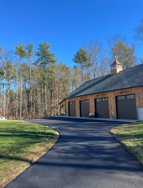 A driveway leading to a house with a lot of garage doors.