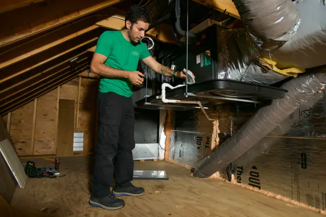 MJ Pro Energy technician servicing an attic air handler