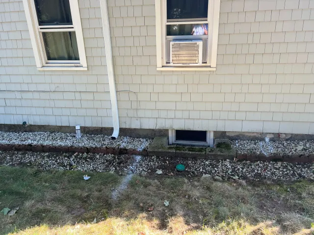 Gray house with white trim, windows, AC unit, and gutter