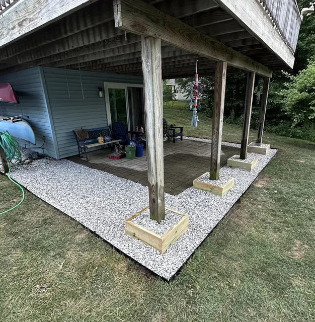 White gravel drainage bed installed around deck support posts by L&D Property Maintenance in Essex, VT