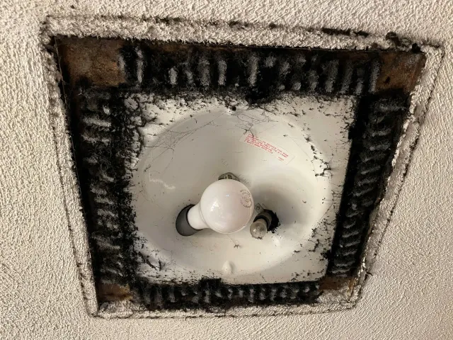 A light bulb is sitting in a hole in the wall.