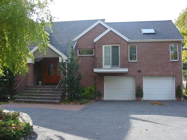 A large red brick house with two white garage doors