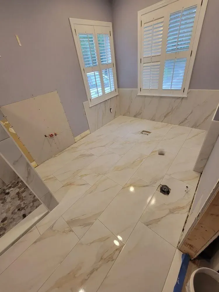 Luxury bathroom with white marble-look tile floor, marble vanity wall
