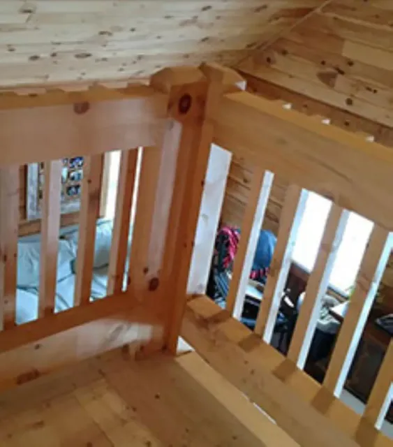 A wooden staircase with a wooden railing and a wooden floor