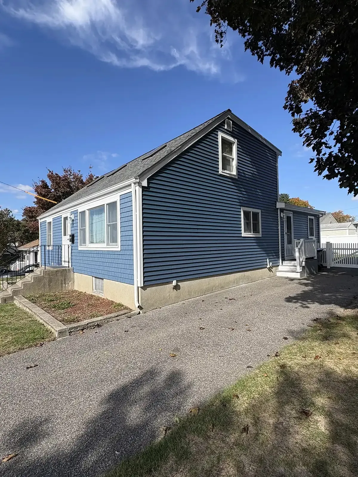 Two-tone blue siding and shingle accent on a cape