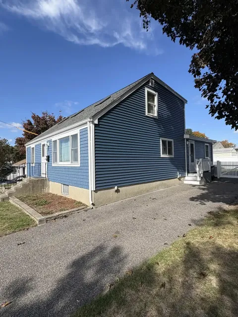 Two-tone blue siding and shingle accent on a cape
