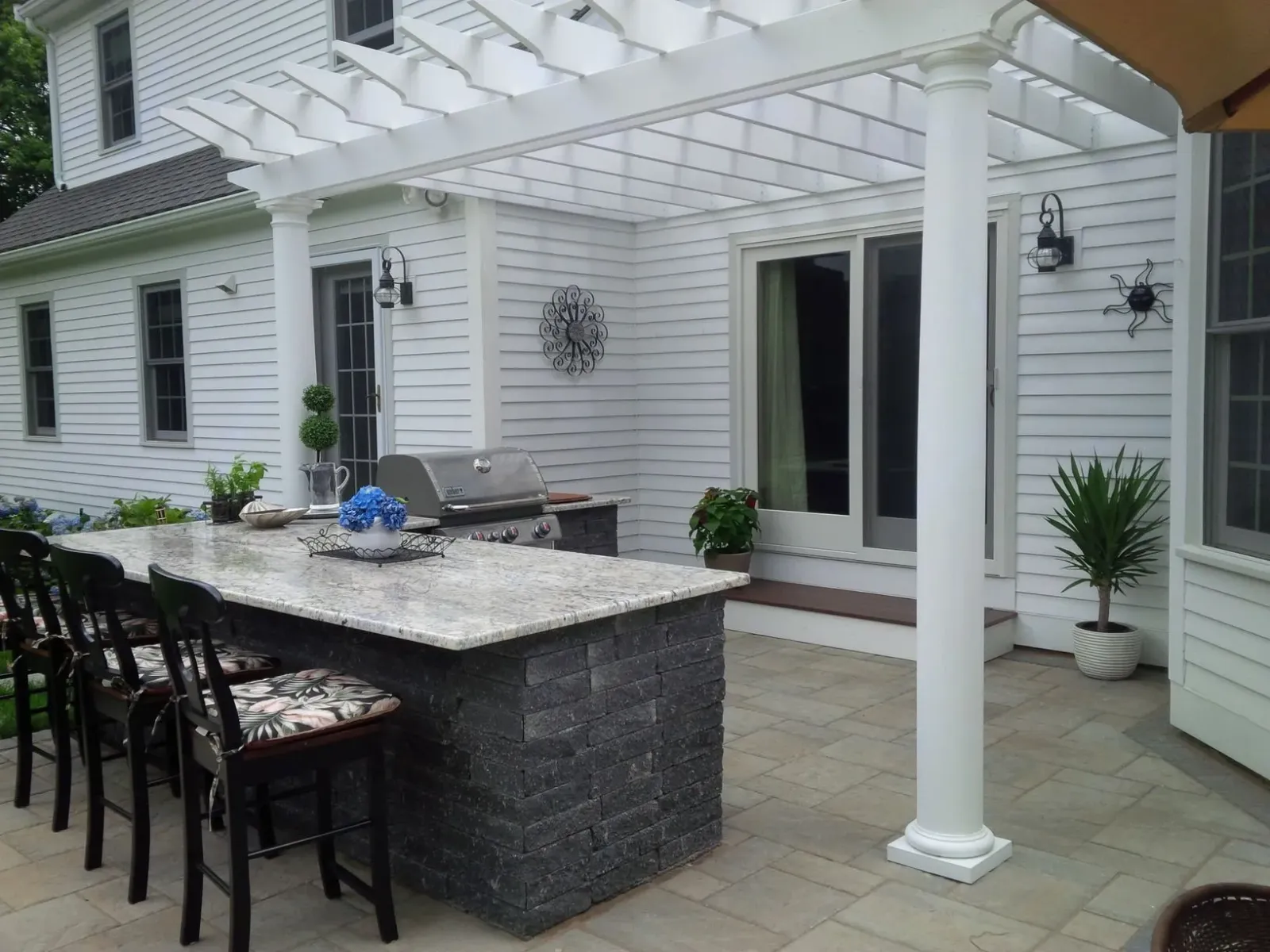 A patio with a pergola and a table and chairs