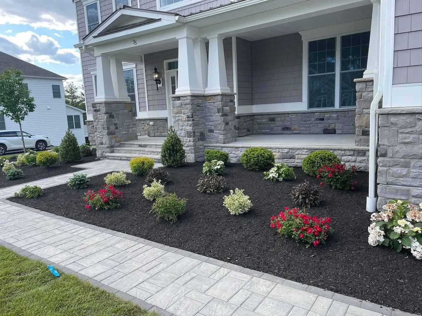 a house with a lush green lawn and flowers in front of it