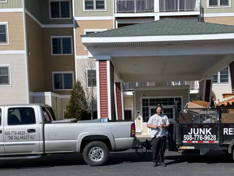 Affordable Hauling truck and worker in front of an assistant living building for clean out service