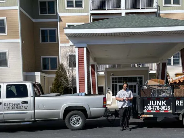 Affordable Hauling truck and worker in front of an assistant living building for clean out service