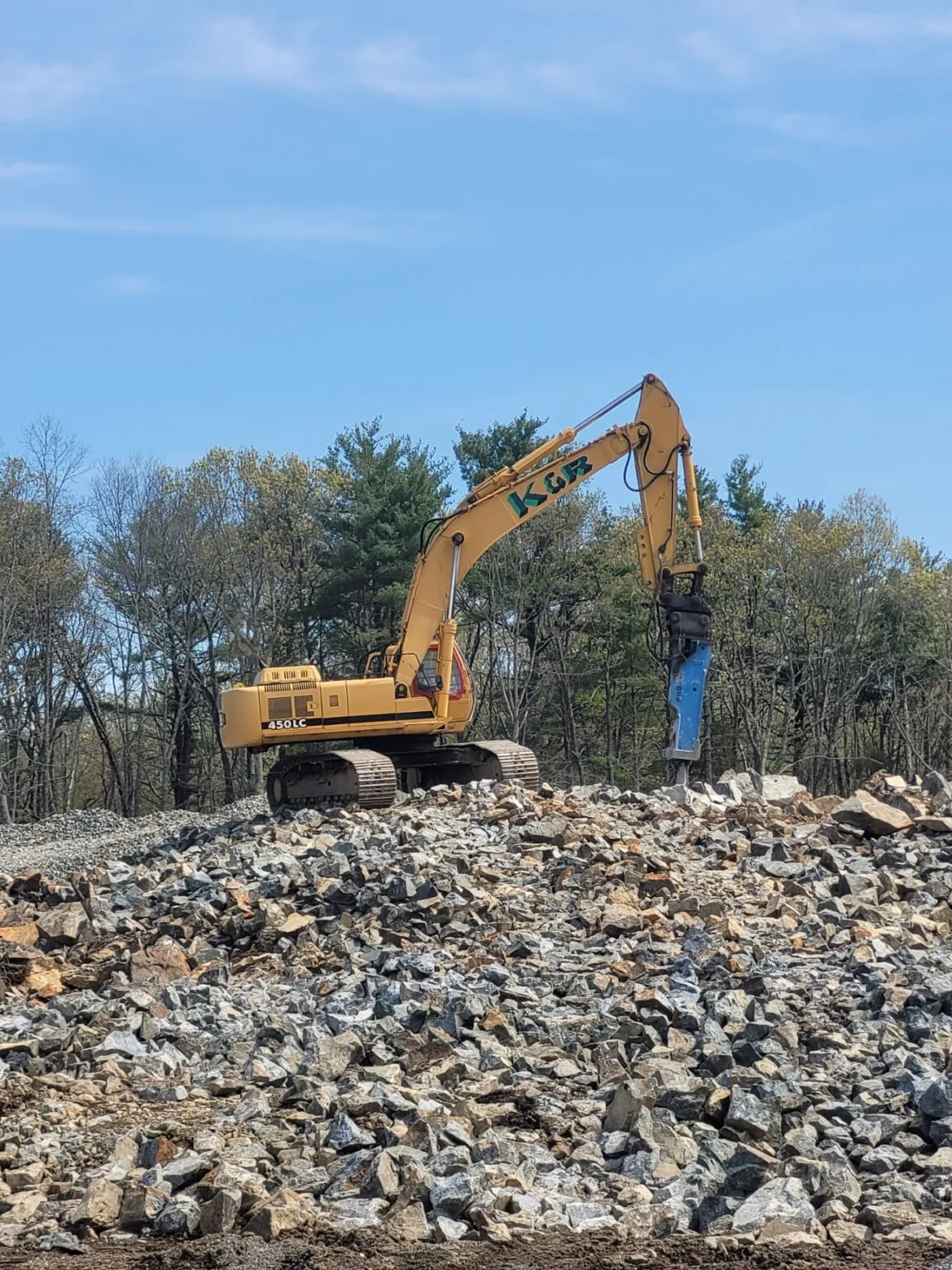 Yellow excavator on rocky construction site