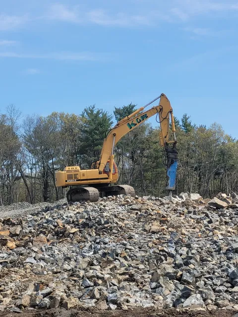 Yellow excavator on rocky construction site