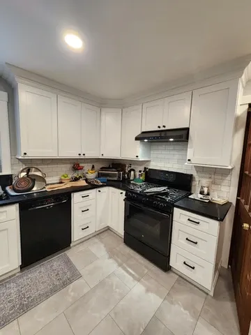 White shaker kitchen with subway tile backsplash and black countertops in Seacoast NH