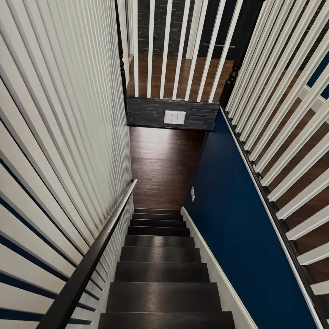 Dark wood staircase with custom slat accent walls and navy paint in Malden, MA — Tinbercraft Construction