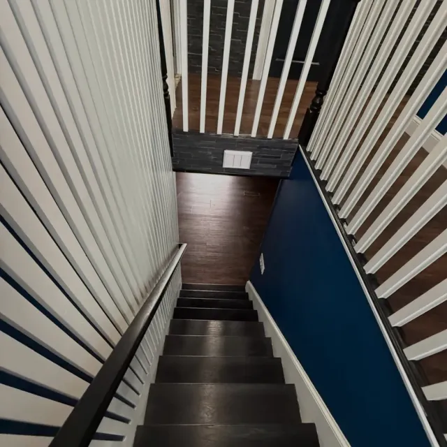 Dark wood staircase with custom slat accent walls and navy paint in Malden, MA — Tinbercraft Construction
