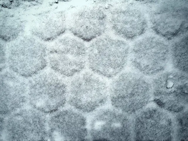 Snow-covered surface with a hexagonal pattern pressed into it.