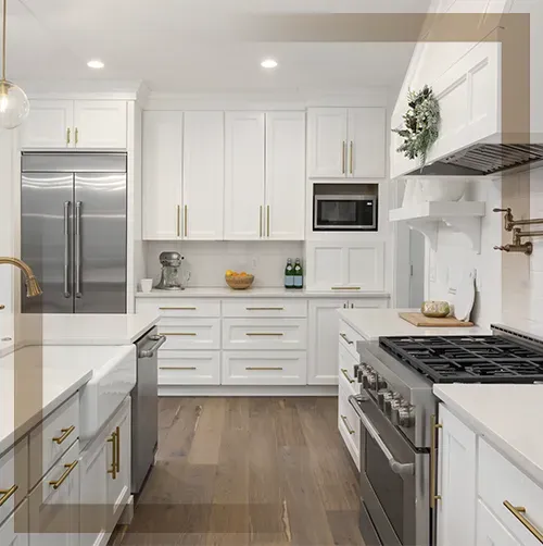Custom white kitchen cabinets with elegant gold handles and professional-grade stainless steel appliances.