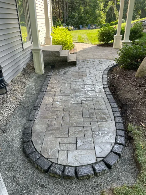 Curved limestone walkway with a charcoal border built by The Englishmen Masonry