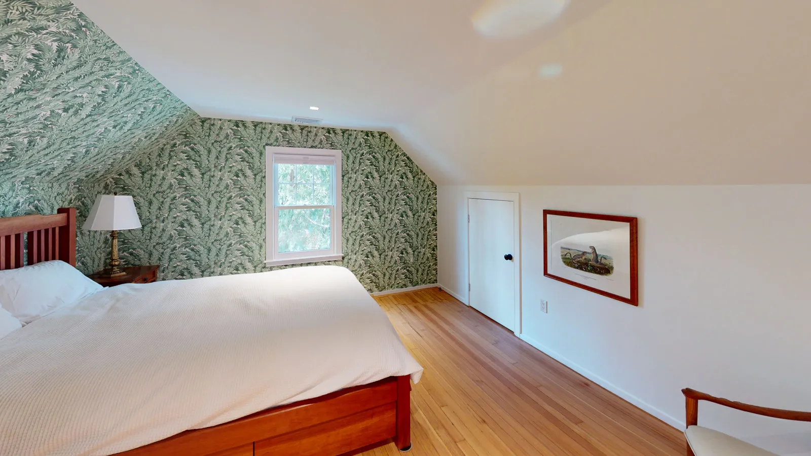 Third-floor bedroom with patterned wallpaper and refinished floors