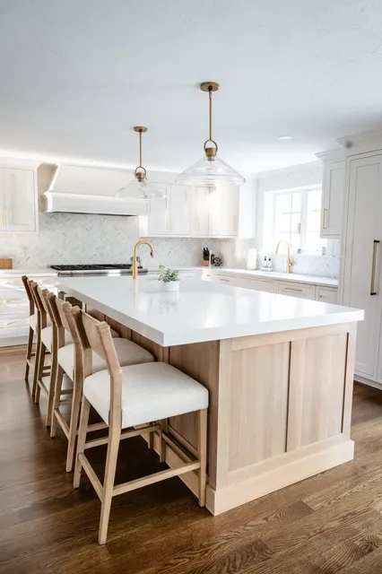 Rosewood Court kitchen with white oak island, glass pendant lights with brass fittings, and all-white cabinetry