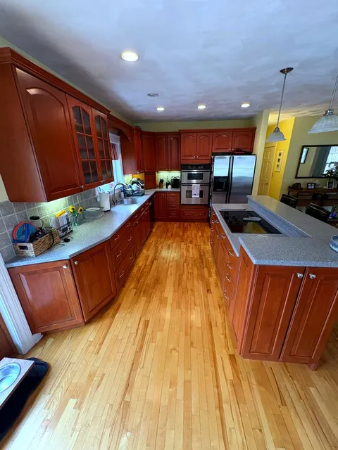 Clean kitchen with cherry wood cabinets and granite counters