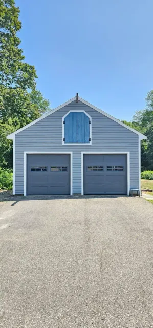 Two gray raised-panel doors on a blue house