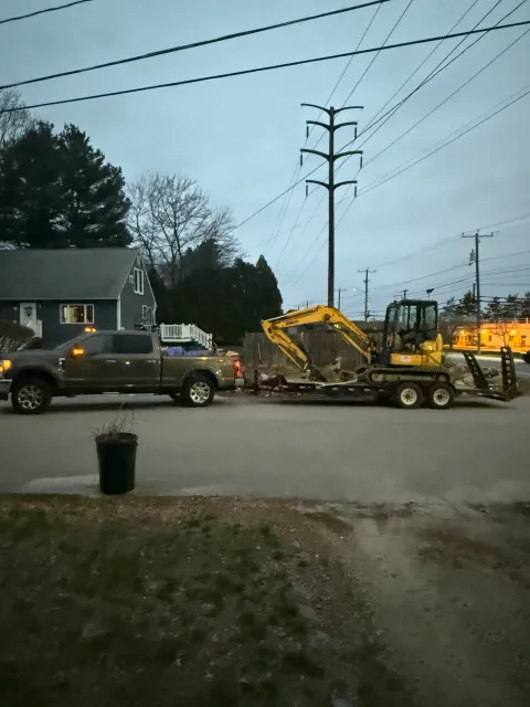 Compact excavator loaded on a trailer for transport