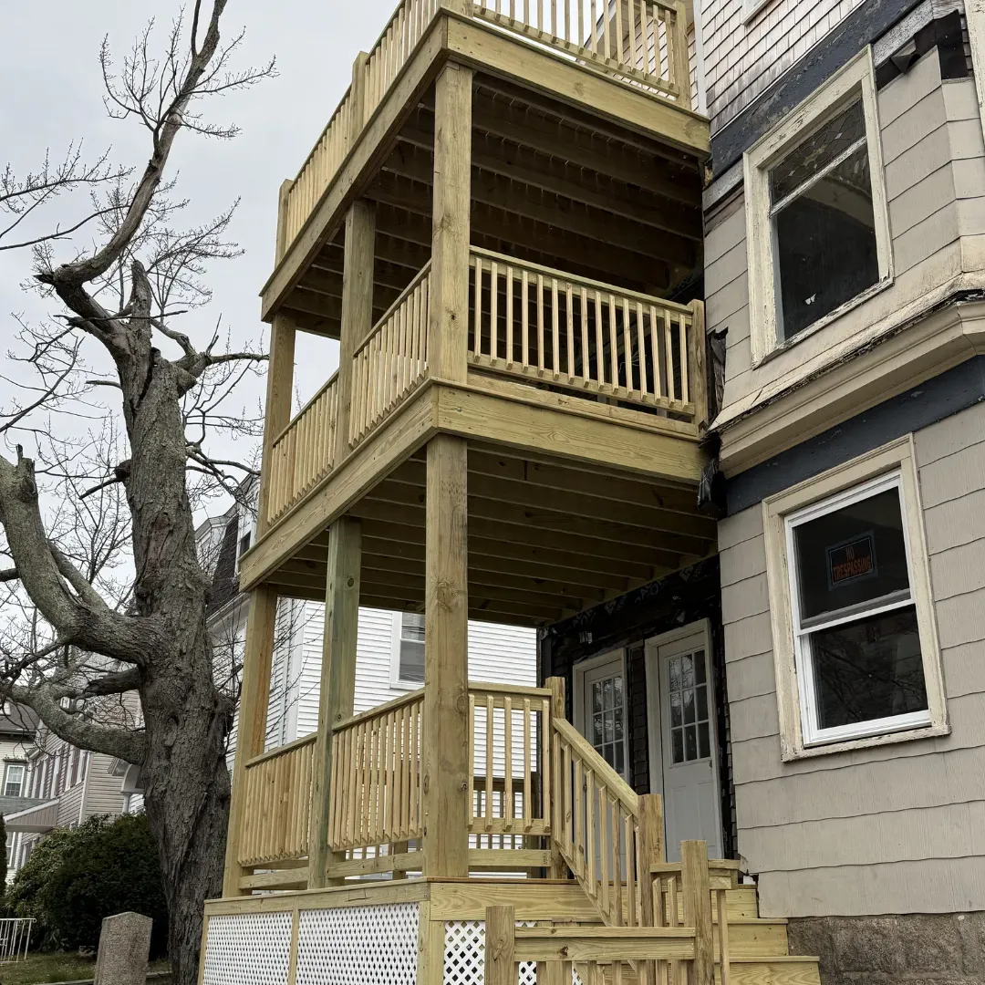 Three-story pressure-treated porch and deck with railings in Medford, MA — Tinbercraft Construction