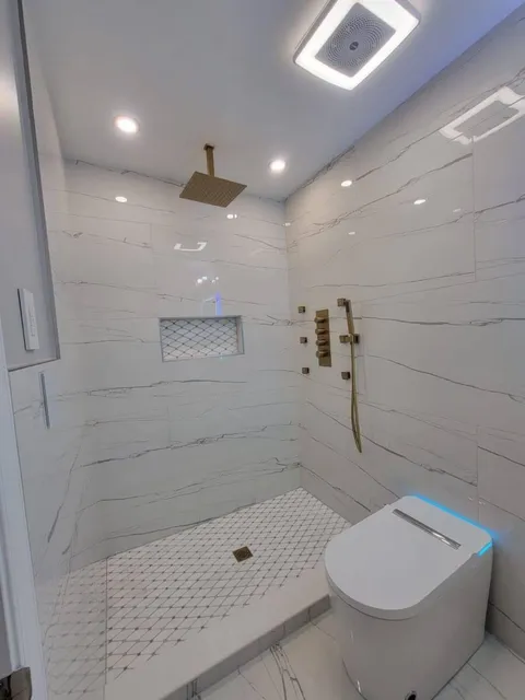 Marble-look shower, gold trim — Reno Art Construction project