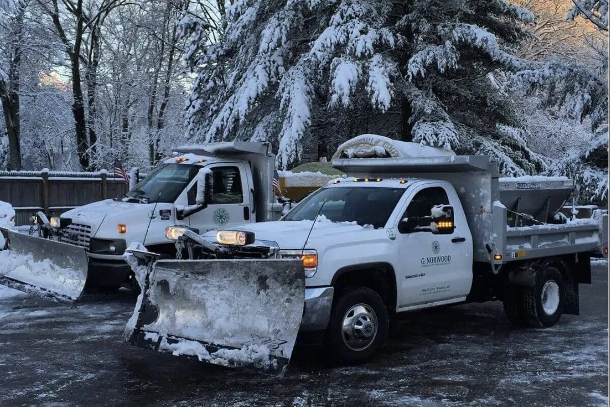 A white truck with snow plow in the back