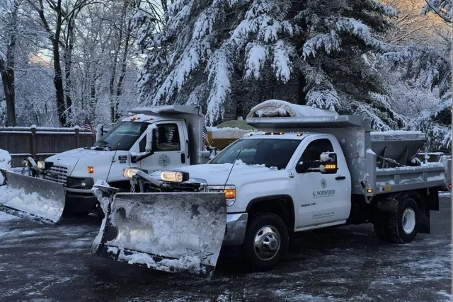 A white truck with snow plow in the back