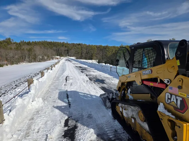 Commercial snow plowing truck clearing a driveway