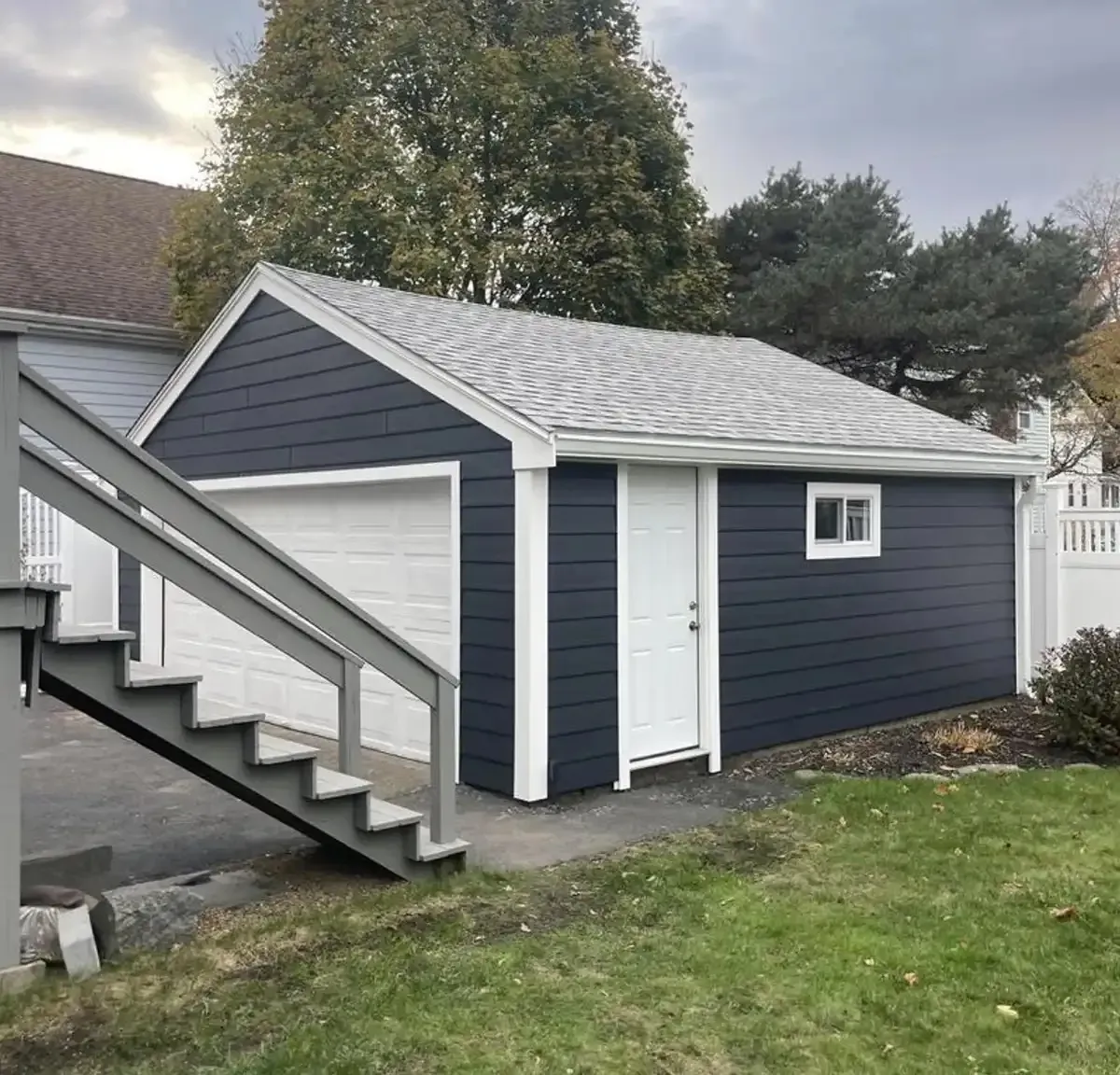 Detached garage with navy fiber-cement siding and new roof