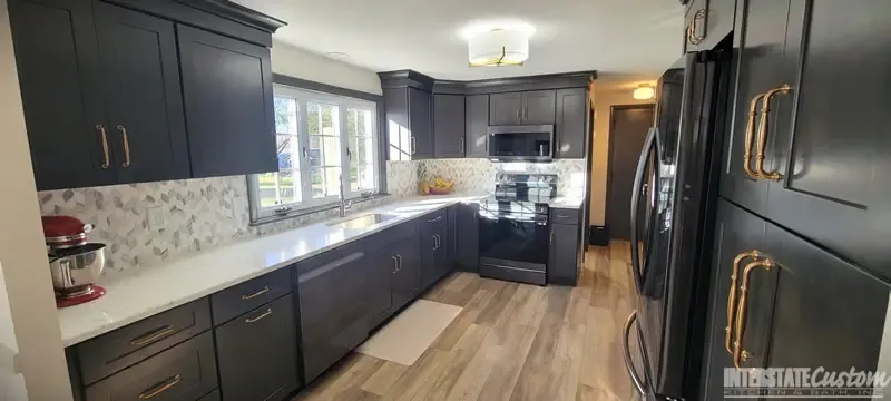 Another angle of the Simply Elegant kitchen remodel showcasing North Point cabinetry in a shaker style maple slate door, Hanstone Chantilly lace quartz countertops, and natural marble braided mosaic tile backsplash. Project by Interstate Custom Kitchen & Bath, Inc.