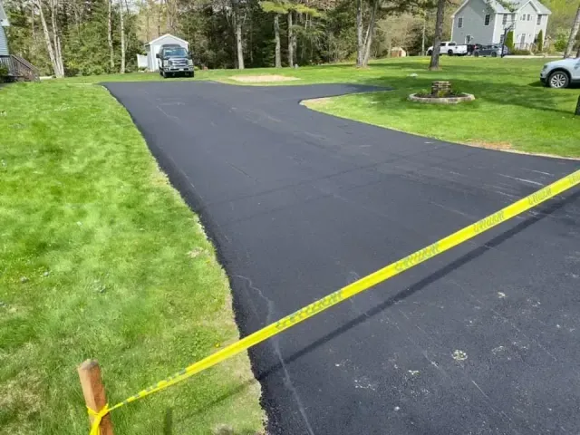 A black road with a yellow tape along the side of it.