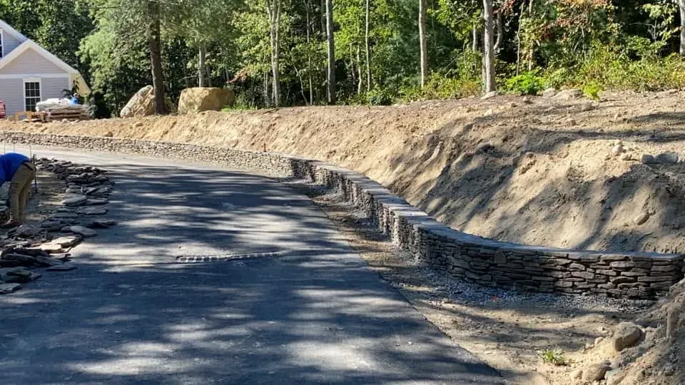 Curving stone retaining walls shaping a residential driveway