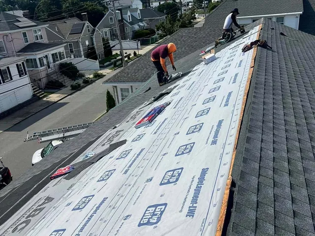 Crew laying underlayment during a roof repair