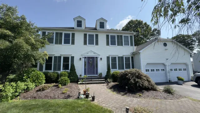 White two-story house with a garage and manicured landscaping
