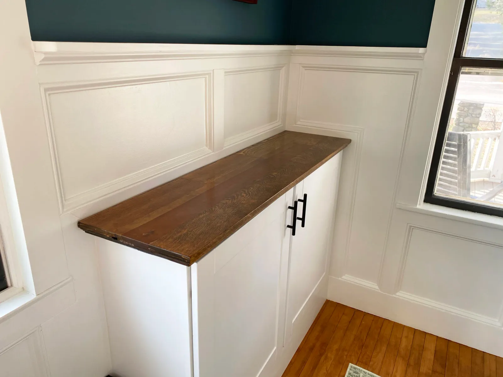 Custom wainscoting, cabinets, and a cabinet top created using an antique door belonging to the client