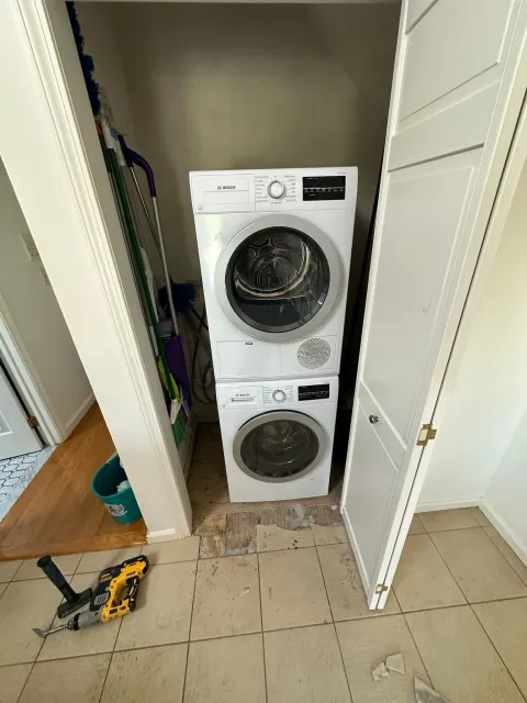 Workers removing large refrigerator through kitchen doorway