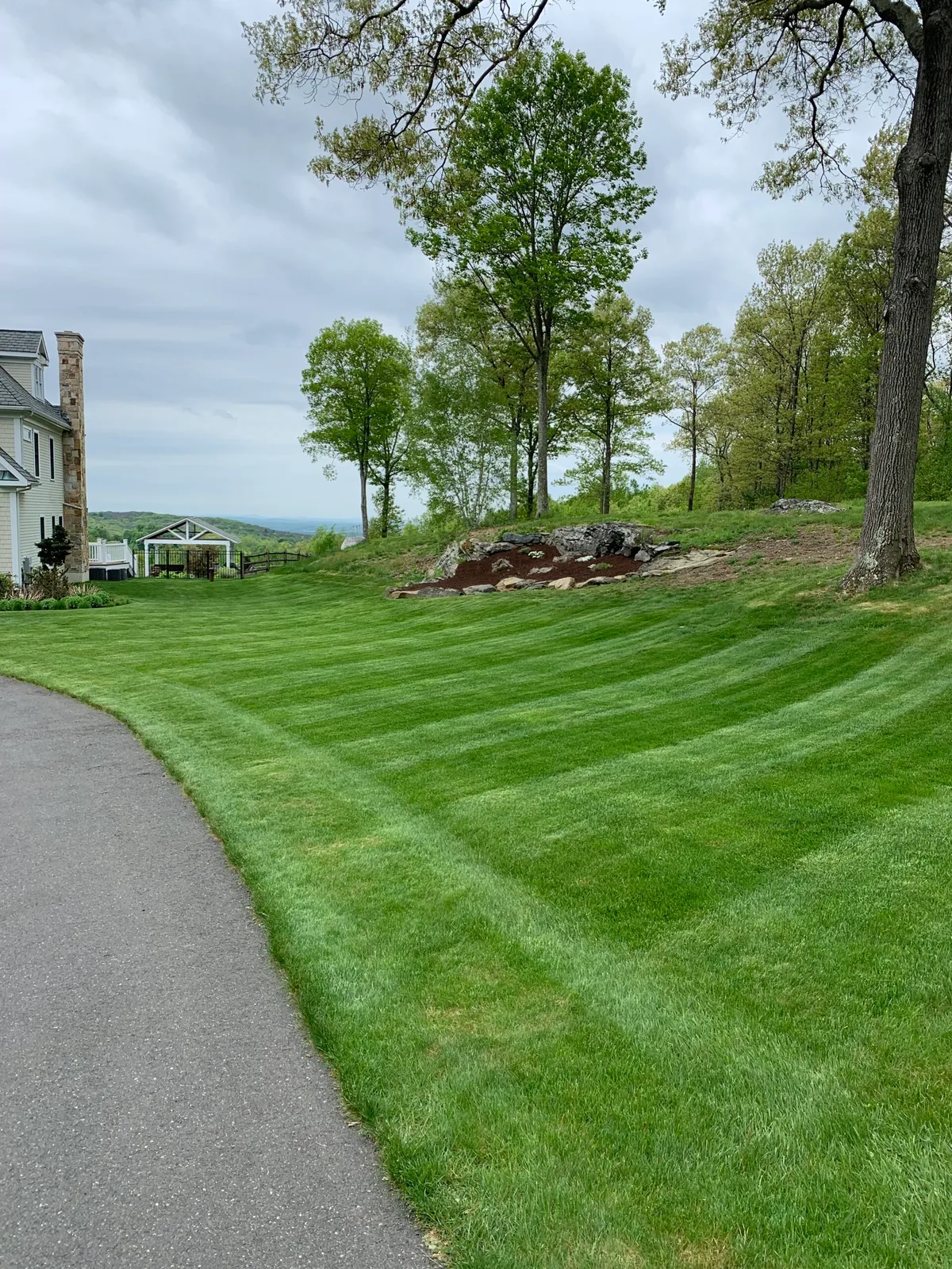 Lush, green lawn at a residential property, illustrating the expert lawncare and landscaping services offered by Keith Isham