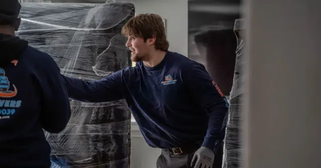 Cyan Movers professional movers wrapping and protecting furniture during a residential move in Manchester CT