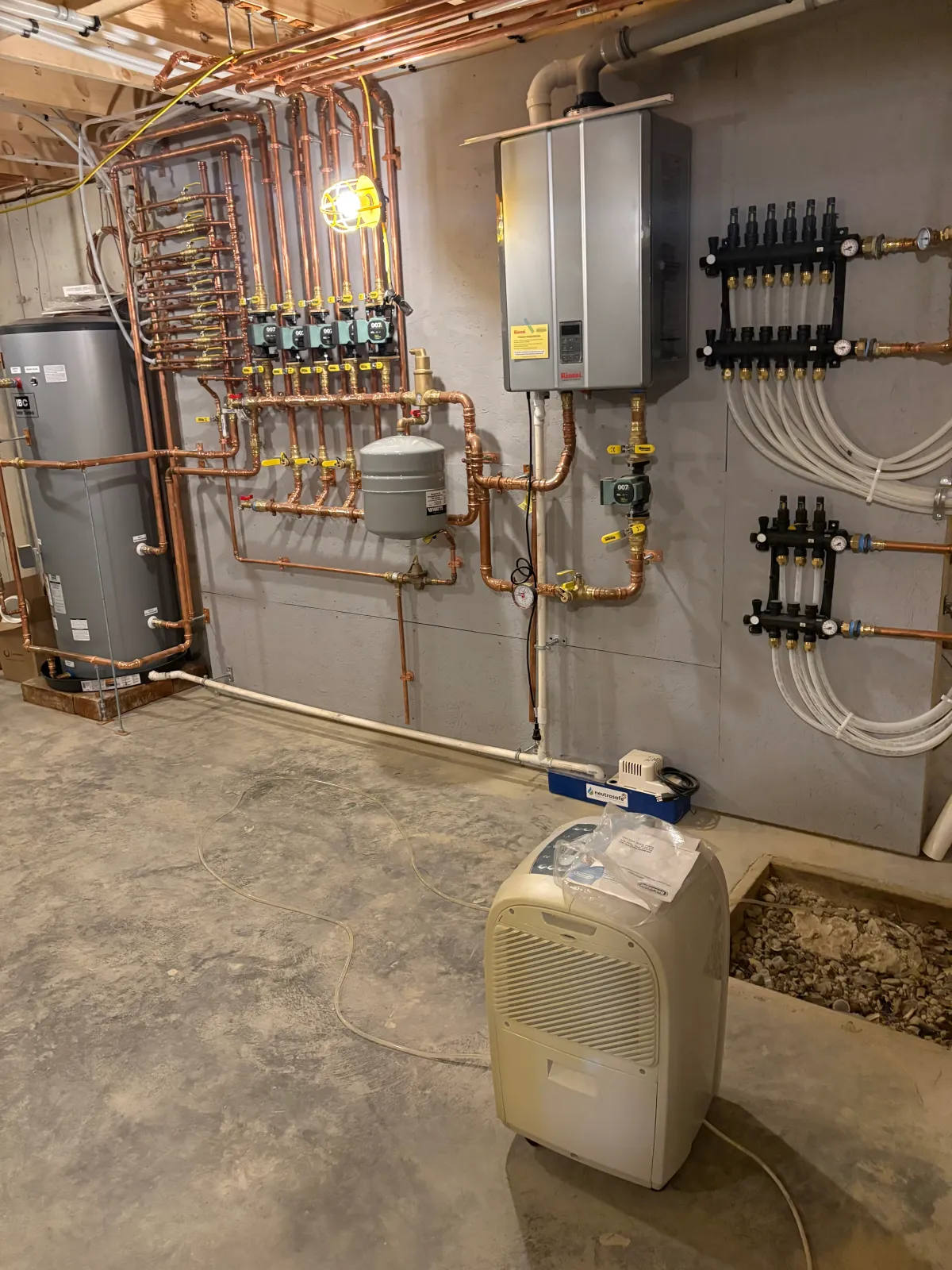 Radiant heating system with copper piping, manifolds, and tankless water heater installation