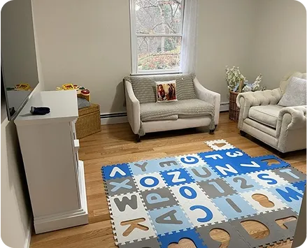 A beautifully organized and clean living room with light grey sofas and tidy floors, showcasing the results of top-tier residential cleaning.