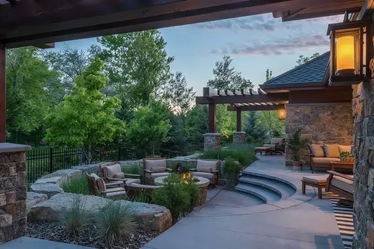 Outdoor fireplace and kitchen masonry installation in Mashpee, Cape Cod featuring custom stone fireplace, built-in seating, and precision hardscape detailing.