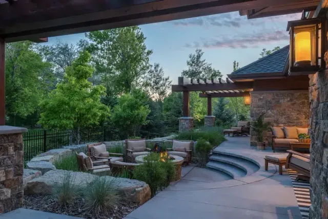 Outdoor fireplace and kitchen masonry installation in Mashpee, Cape Cod featuring custom stone fireplace, built-in seating, and precision hardscape detailing.